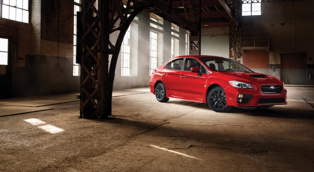 A red 2017 Subaru WRX is shown parked in a warehouse.