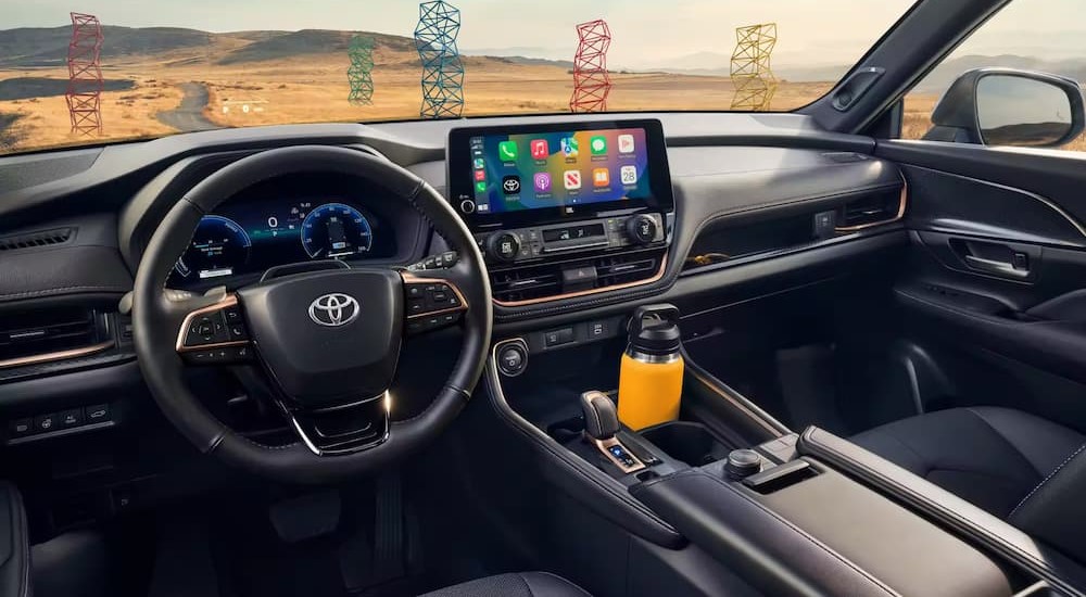 The black interior and dash of a 2024 Toyota Grand Highlander is shown.