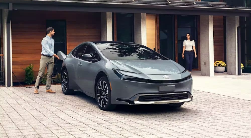 A gray 2023 Toyota Prius Prime is shown parked near a house.