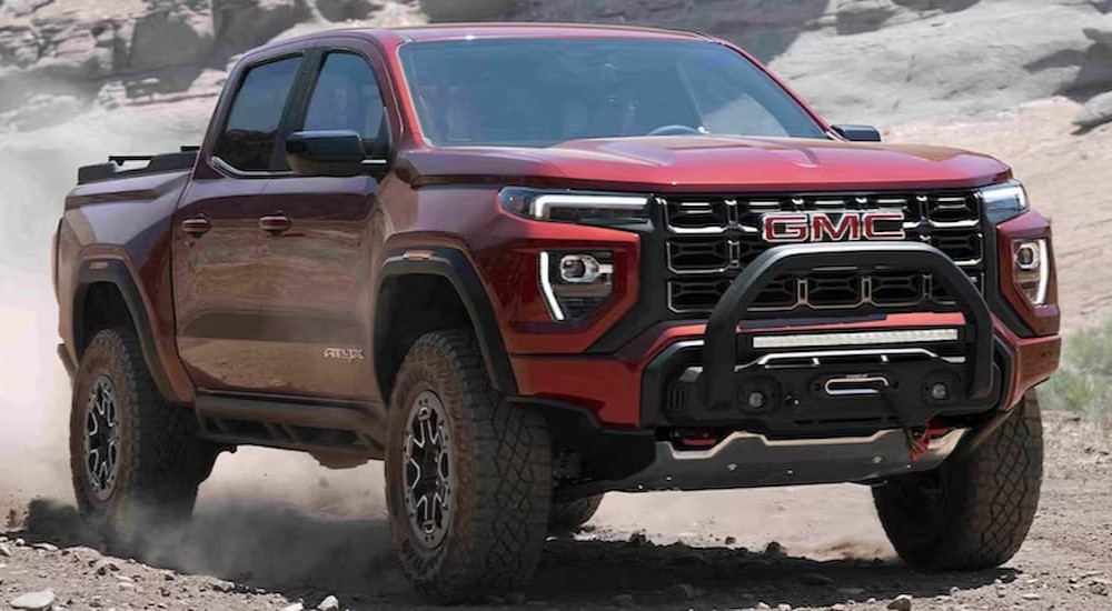 A red 2023 GMC Canyon AT4X is shown driving off-road.