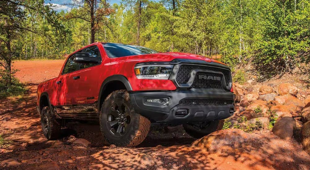 A red 2023 Ram 1500 Rebel is shown off-roading.