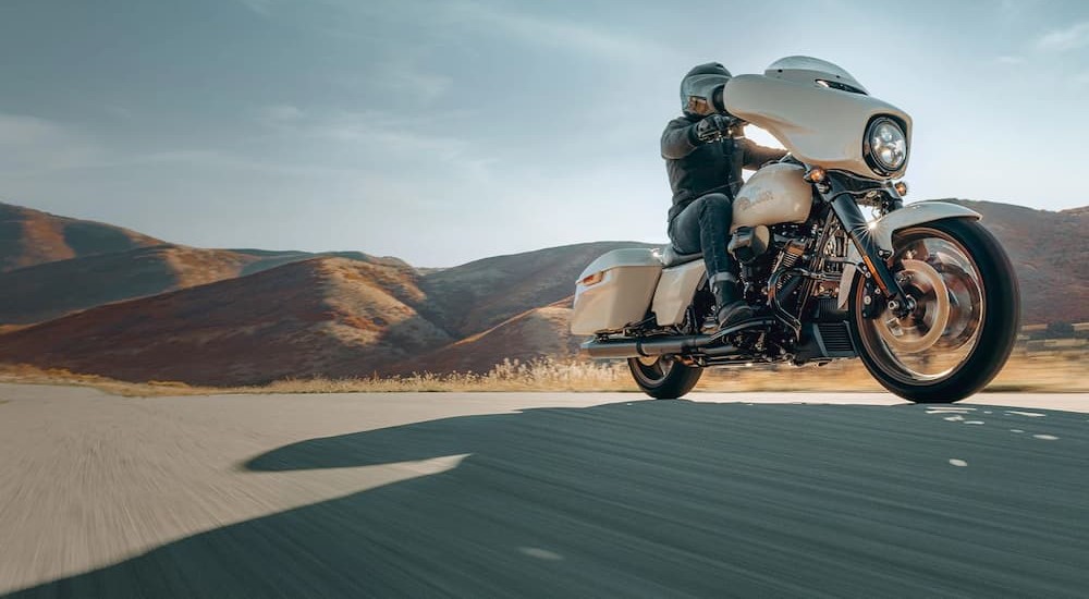A white 2023 Harley-Davidson Street Glide is shown riding on a highway.