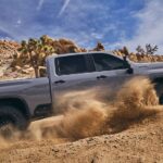 A silver 2024 Chevy Silverado 2500 HD ZR2 is shown from the side while off-road.