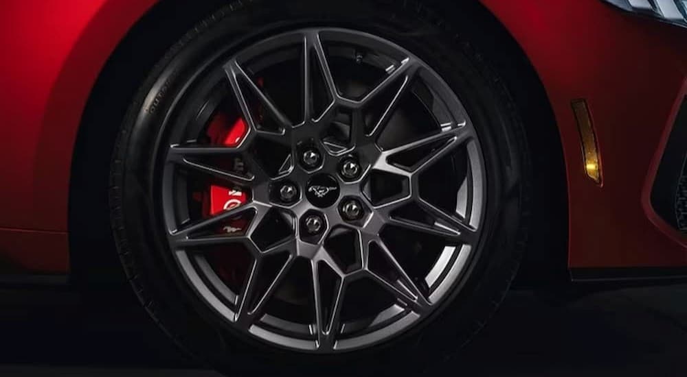 A wheel is shown on a red 2024 Ford Mustang.