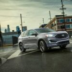 A grey 2023 Ford Edge ST is shown from the front at an angle during a 2023 Ford Edge vs 2023 Jeep Grand Cherokee comparison.