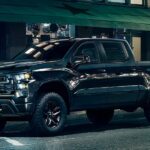 A popular Chevy Silverado for sale, a black 2023 Chevy Silverado 1500 Midnight Trail Boss Z71, is shown parked on a city street.