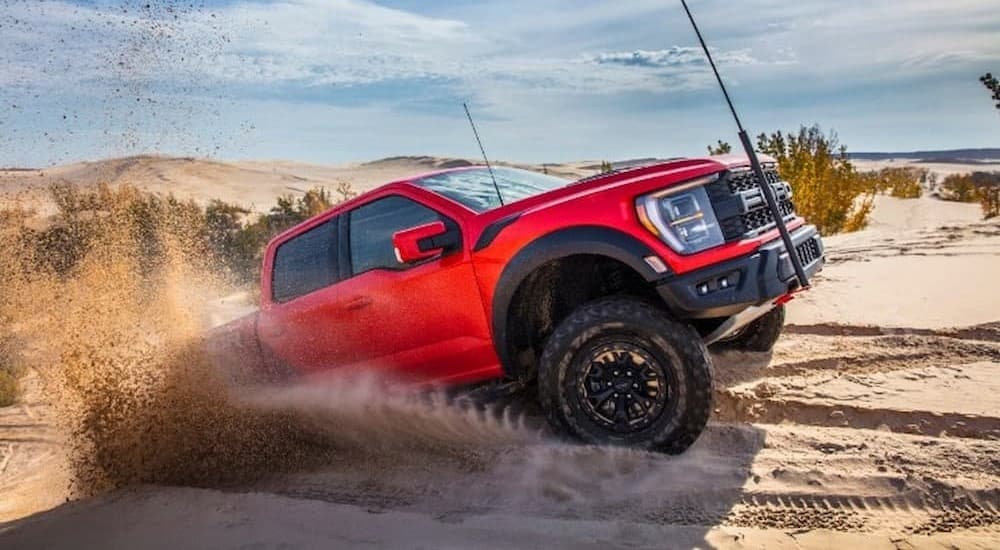 A red 2023 Ford F-150 Raptor R is shown off-roading.