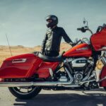 A red 2023 Harley-Davidson Road Glide is shown parked near a person.
