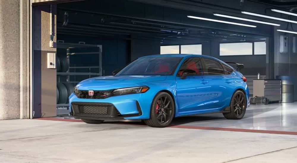 A blue 2023 Honda Civic Type-R is shown parked inside of a garage.