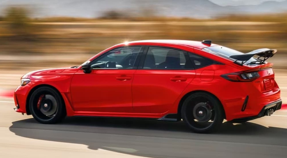 A red 2023 Honda Civic R-Type is shown driving on a road.