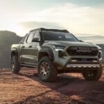 A green 2024 Toyota Tacoma Trailhunter is shown from the front at an angle after leaving a dealer that has a Toyota Tacoma for sale.