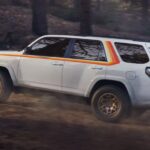 A white 2023 Toyota 4Runner 40th Anniversary Edition is shown off-roading.