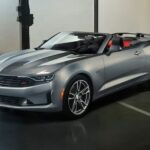 A popular cheap used car, a silver 2019 Chevy Camaro 1LT RS, is shown parked in a garage.