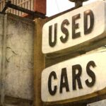 A used cars for sale sign is shown.