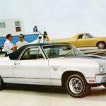 A white 1970 Chevy El Camino SS is shown parked near a Chevy dealer.