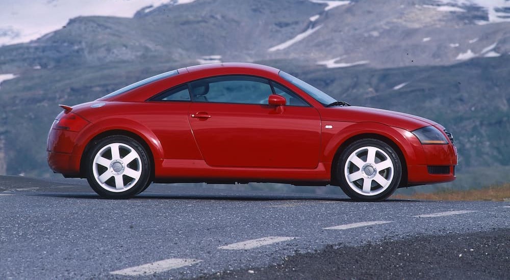 A red 2000 Audi TT is shown parked on a mountain road.