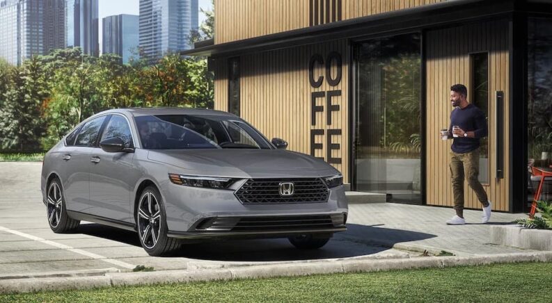 A gray 2023 Honda Accord is shown parked near a coffee shop after visiting a Honda dealer.