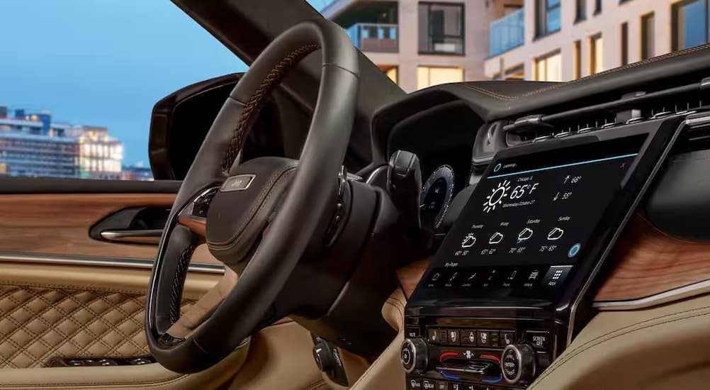 The tan and black interior and dash of a 2023 Jeep Grand Cherokee L is shown.