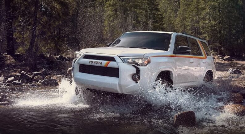 A white 2023 Toyota 4Runner 40th Anniversary Special Edition is shown driving off-road on water.