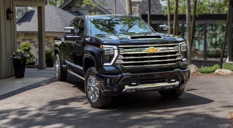 A black 2024 Chevy Silverado 3500 HD High Country is shown parked on a driveway after viewing a Chevy Silverado 3500 HD for sale.