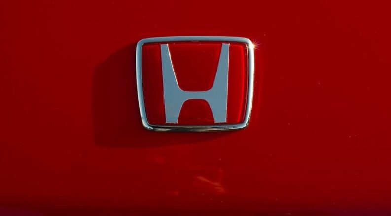 A closeup of a Honda badge shown at a Honda dealer.