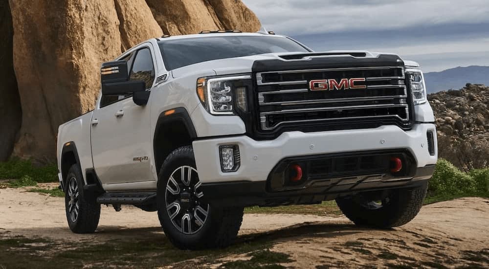 A white 2023 GMC Sierra 2500 HD AT4 is shown parked off-road.