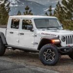 A popular Jeep Gladiator for sale, a white 2023 Jeep Gladiator Rubicon, is shown parked near a cliff.