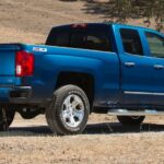 A blue 2018 Chevy Silverado 1500 is shown from the rear at an angle after leaving a dealer that has a used Chevy Silverado 1500 for sale.