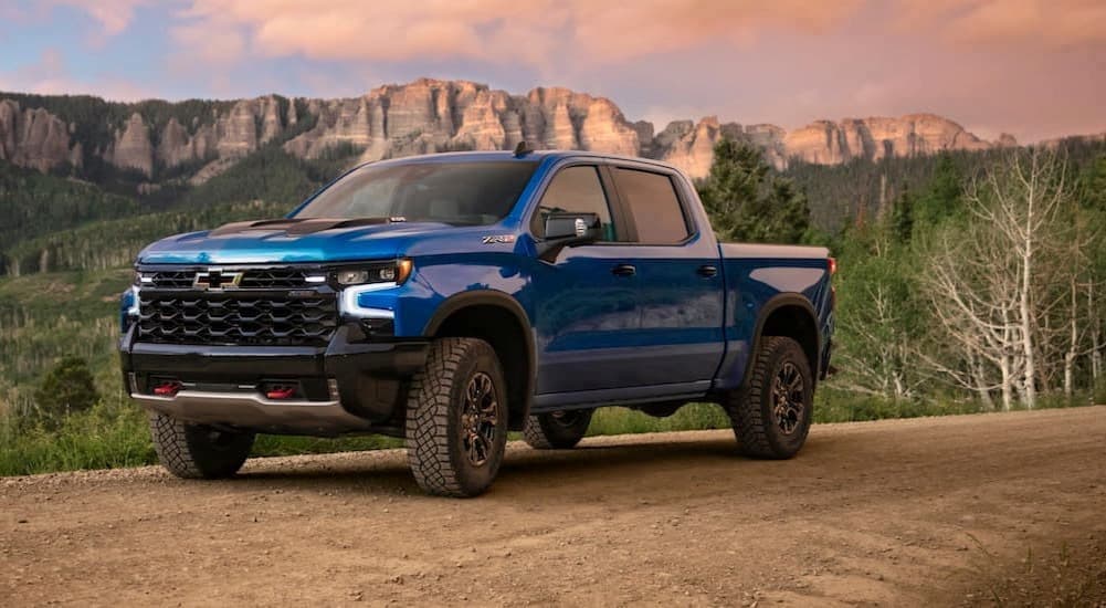 A blue 2023 Chevy Silverado 1500 ZR2 is shown parked on a dirt road.