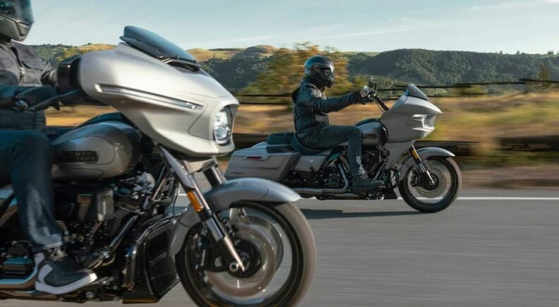Two silver 2023 Harley-Davidson CVO Street Glides are shown driving on a highway.