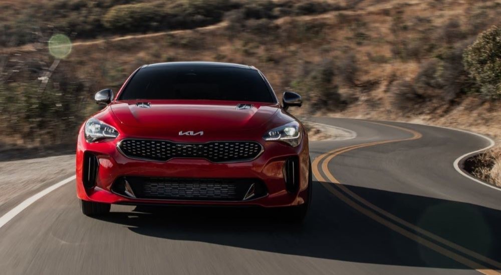 A red 2023 Kia Stinger is shown driving.