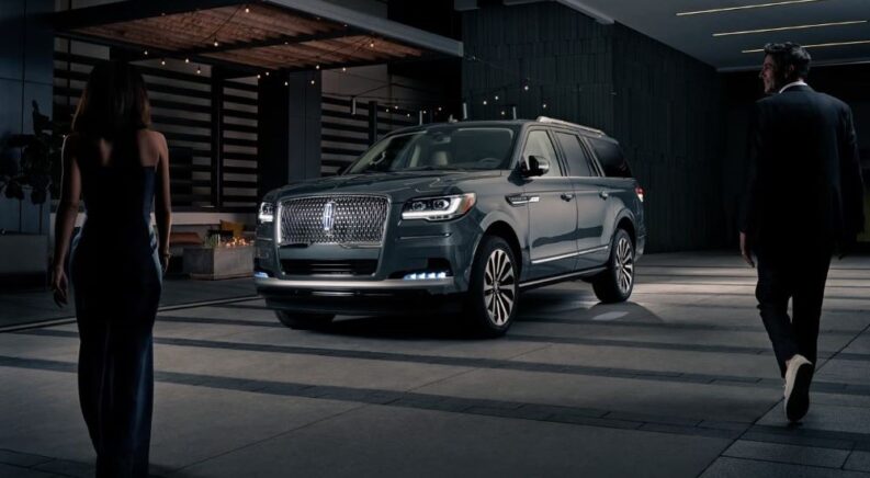 One of the more powerful used SUVs for sale, a black 2023 Lincoln Navigator, is shown parked at a party.