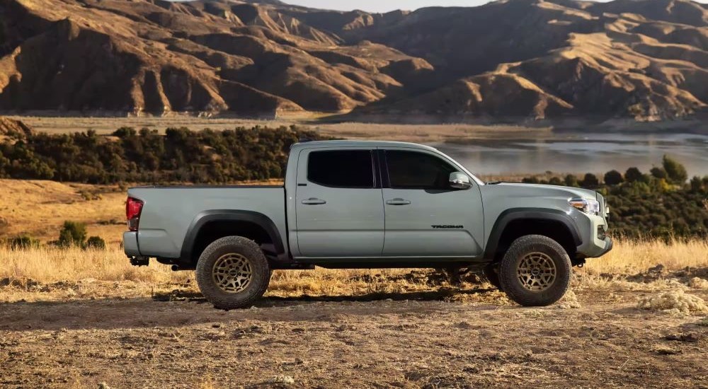 A white 2023 Toyota Tacoma SR5 Trail Edition is shown parked off-road.