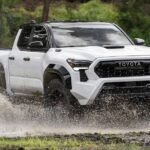 A white 2024 Toyota Tacoma is shown off-roading on water.