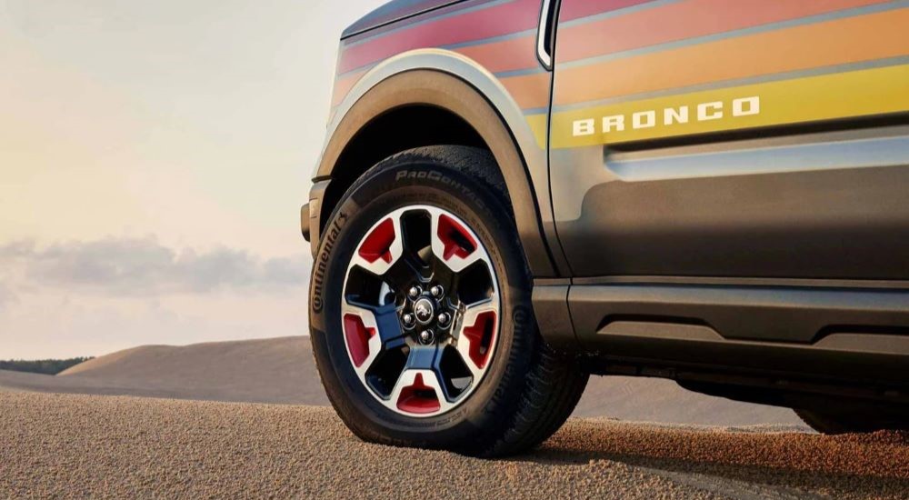 A close up shows the wheel on a Ford Bronco Sport for sale, a multicolored 2024 Ford Bronco Sport Free Wheeling.