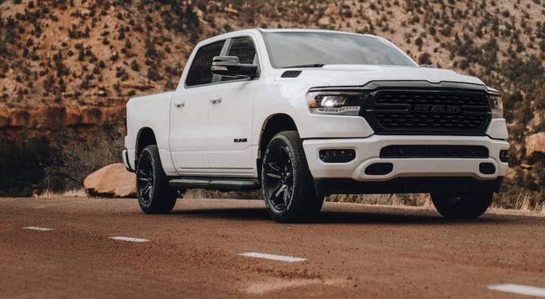 A white 2022 Ram 1500 is shown from the front at an angle while off-road.