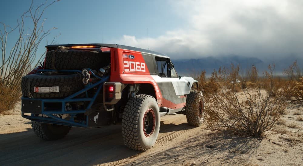 A red and black 2020 Ford Bronco R Race Prototype is shown driving off-road.