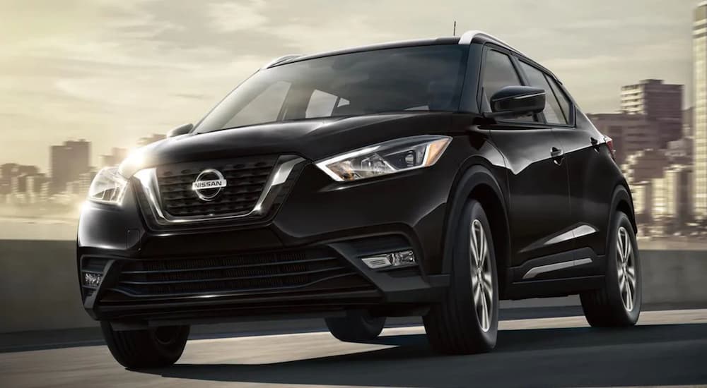 A black 2020 Nissan Kicks is shown driving from the city.
