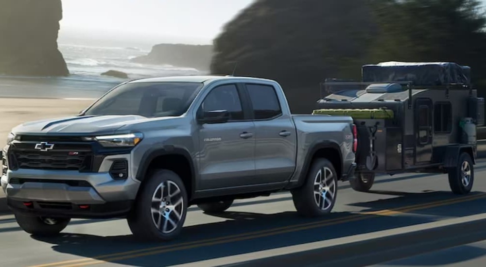 A silver 2023 Chevy Colorado Z71 is shown towing a trailer after visiting a Chevy dealer.