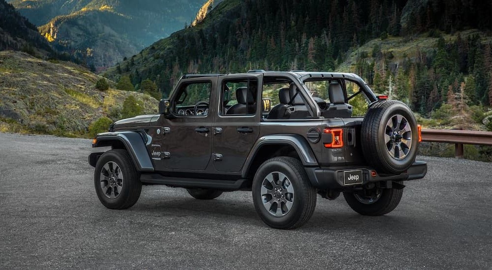 A gray 2023 Jeep Wrangler is shown parked near a mountain.