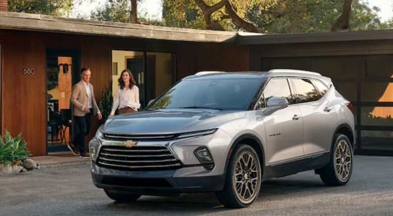 A silver 2024 Chevy Blazer is shown parked near a house.