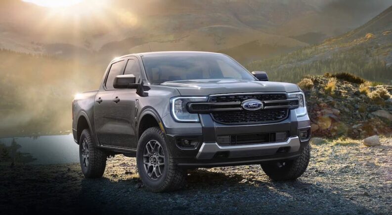 A grey 2024 Ford Ranger is shown driving off-road.