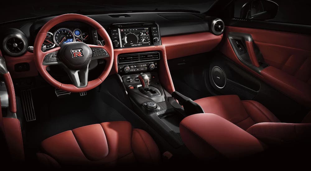 The red and black interior of a 2024 Nissan GT-R is shown.
