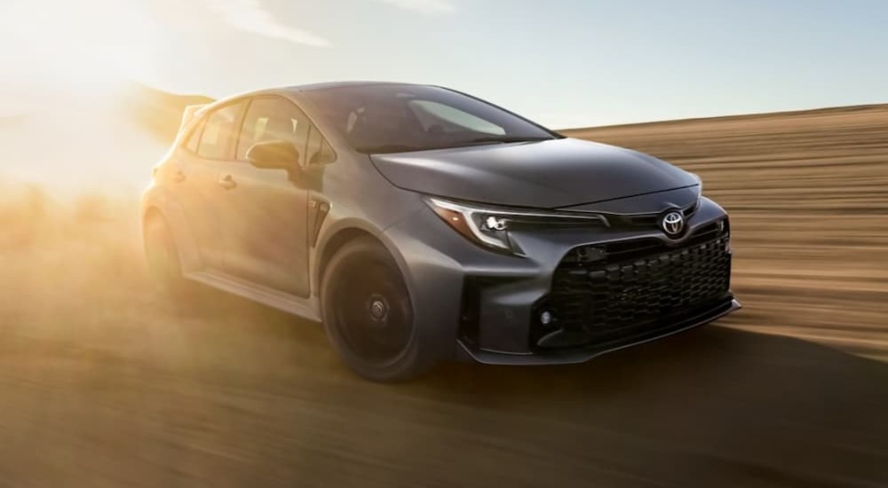 A gray 2024 Toyota GR Corolla is shown driving off-road.