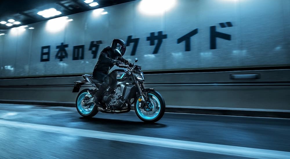 A black and blue 2024 Yamaha MT-09 is shown riding in a tunnel.