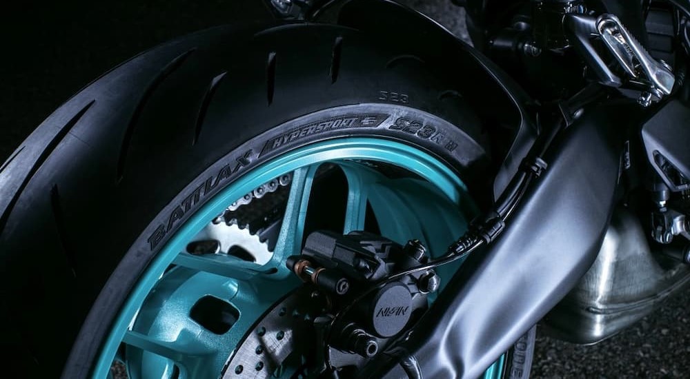 A close-up of a black and blue wheel on a 2024 Yamaha MT-09 is shown.