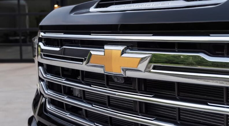 A closeup of the grille on a black 2024 Chevy Silverado 2500HD is shown.