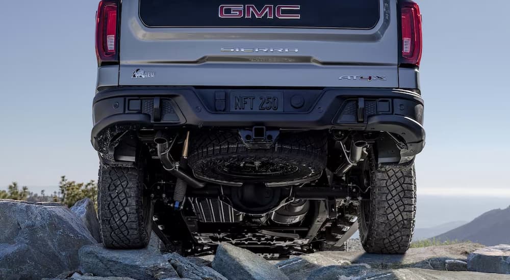 A close up of the rear and suspension of a silver 2023 GMC Sierra 1500 AEV AT4X is shown.