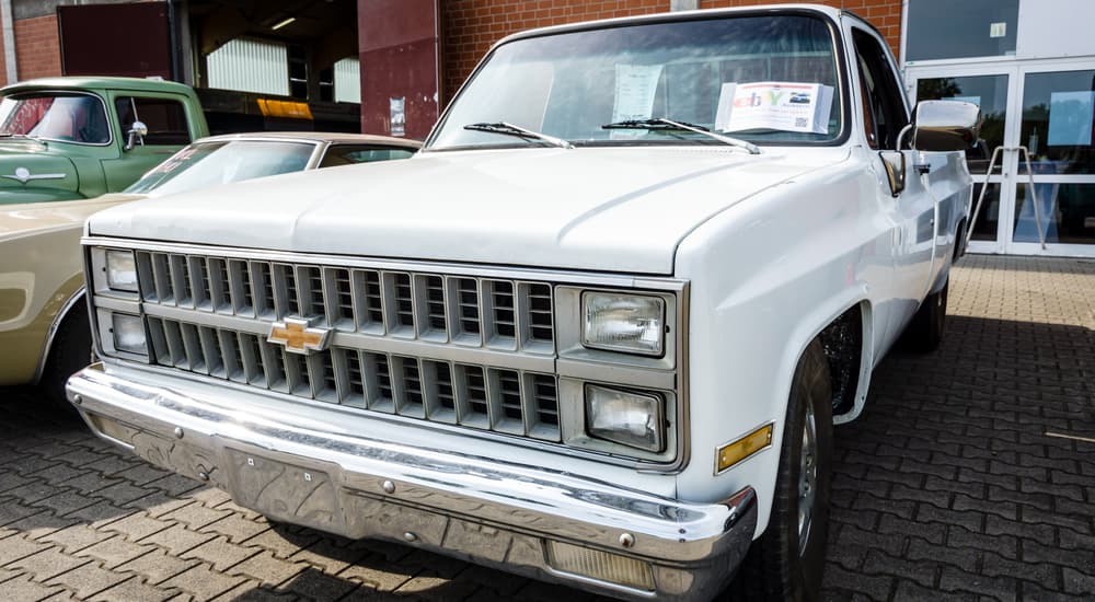 A white 1981 Chevy C/K is shown parked at a car show.