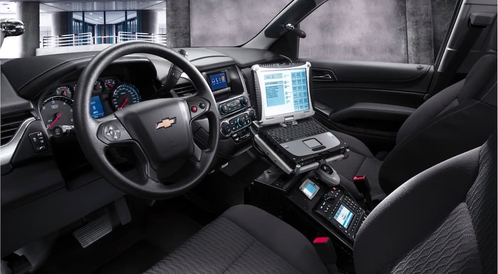 The black interior of a 2016 Chevy Tahoe PPV is shown, featuring a console for police laptops.